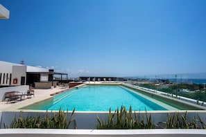 A rooftop swimming pool with lounge chairs and a view of the cityscape. - Musa del Carmen · Garden Patio & Pool Access (Playa del Carmen)