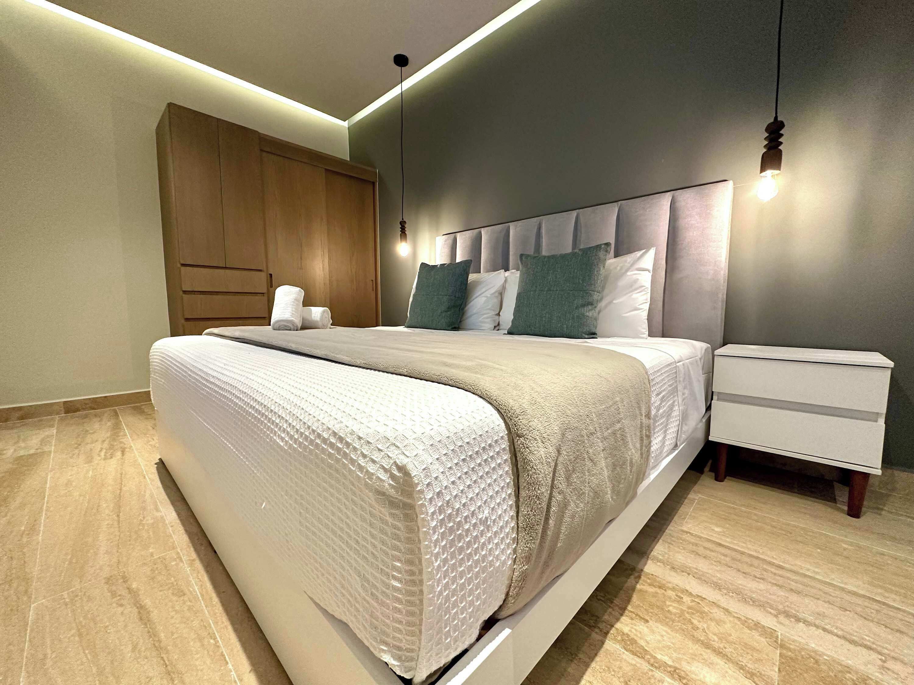 Ein modernes Schlafzimmer mit Bett, Nachttisch und Kleiderschrank.
