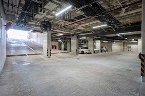 A multi-level parking garage with concrete floors and pillars, equipped with ventilation systems and emergency exits. - Musa del Carmen · Garden Patio & Pool Access (Playa del Carmen)