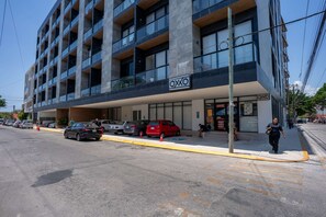 A multi-story building with a commercial ground floor featuring a storefront with the sign 'OXXO.' - Musa del Carmen · Modern 1BR Pool & Hot tub Access (Playa del Carmen)