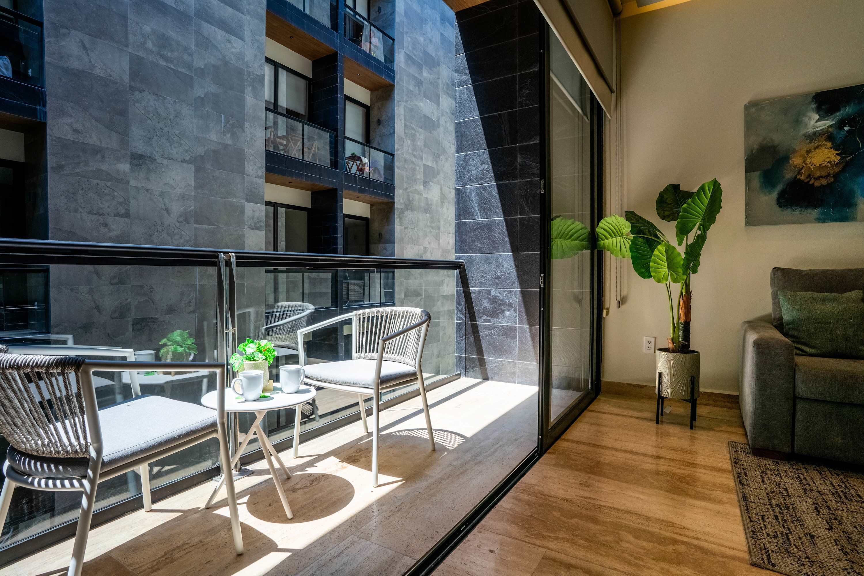 A modern interior with a balcony, seating area, and a potted plant.