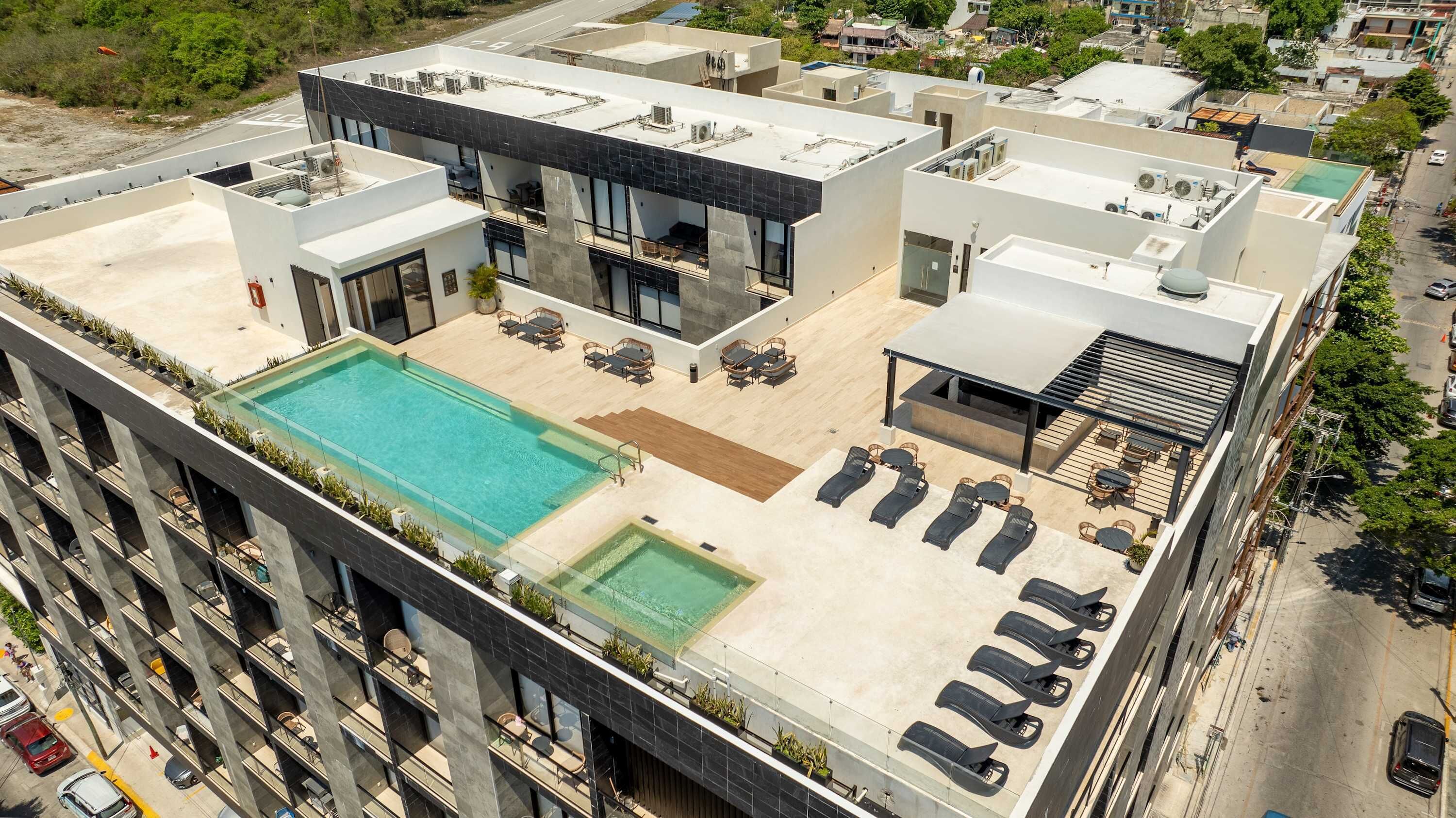A rooftop pool area with lounge chairs and a swimming pool.