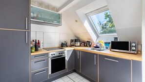 Eine moderne Küche mit Oberlicht, eingebautem Backofen und Mikrowelle.