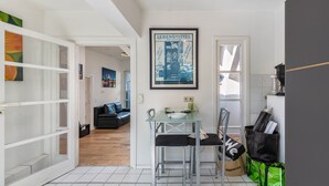 Ett modernt kök med en matplats, en inramad tavla som föreställer en stadsbild och en kaffemaskin.