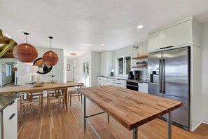 A modern kitchen with a central island, stainless steel appliances, and pendant lighting. - Renovated Door County Bluff Home Panoramic Water Views 4BR Fire pit Sleeps 12 (Sturgeon Bay)