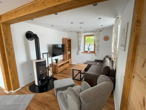 Una sala de estar acogedora con chimenea, sofá, televisor y muebles de madera.