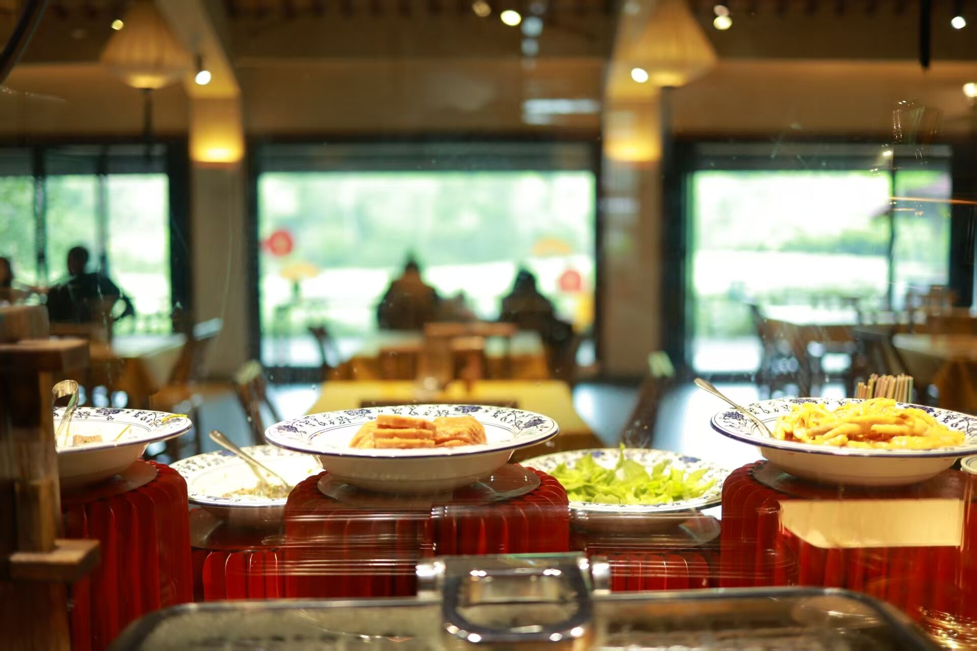 A buffet setup with various dishes and a glass display case in the foreground.
