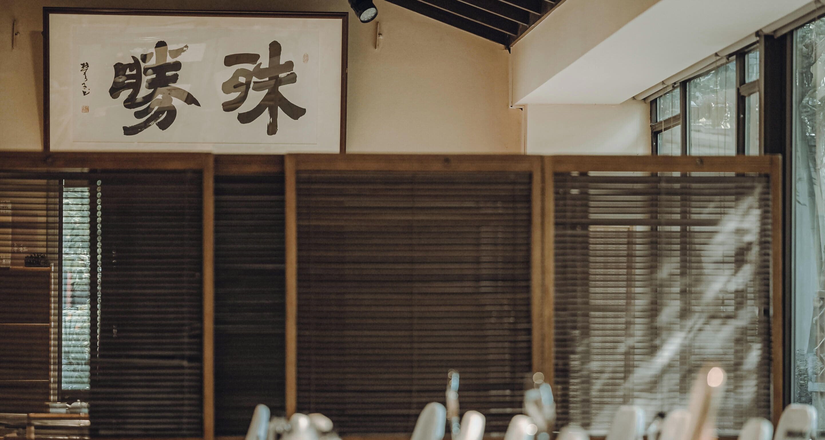 A traditional Japanese interior with sliding doors and a sign with Japanese characters.