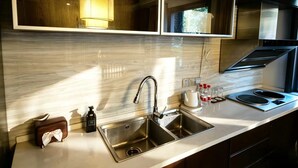 A modern kitchen with a stainless steel sink, a built-in stove, and a mirror above the countertop.