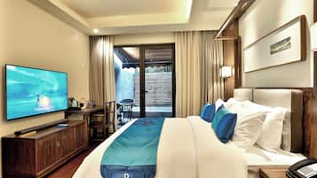 Habitación de hotel con cama, televisión, escritorio y vistas al exterior.