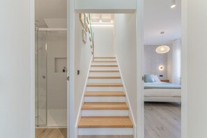 A modern interior with a staircase leading to a bedroom. - Grandma’s House – Renovated Seaside Home in Central Muxía with Garden & Parking (Muxía)