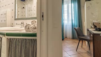 A bathroom with a bathtub, a towel rack, and a checkered curtain.