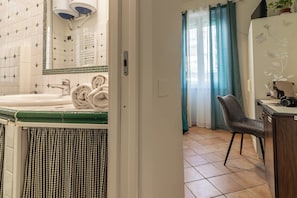 Une salle de bain avec une baignoire, un porte-serviettes et un rideau à carreaux.