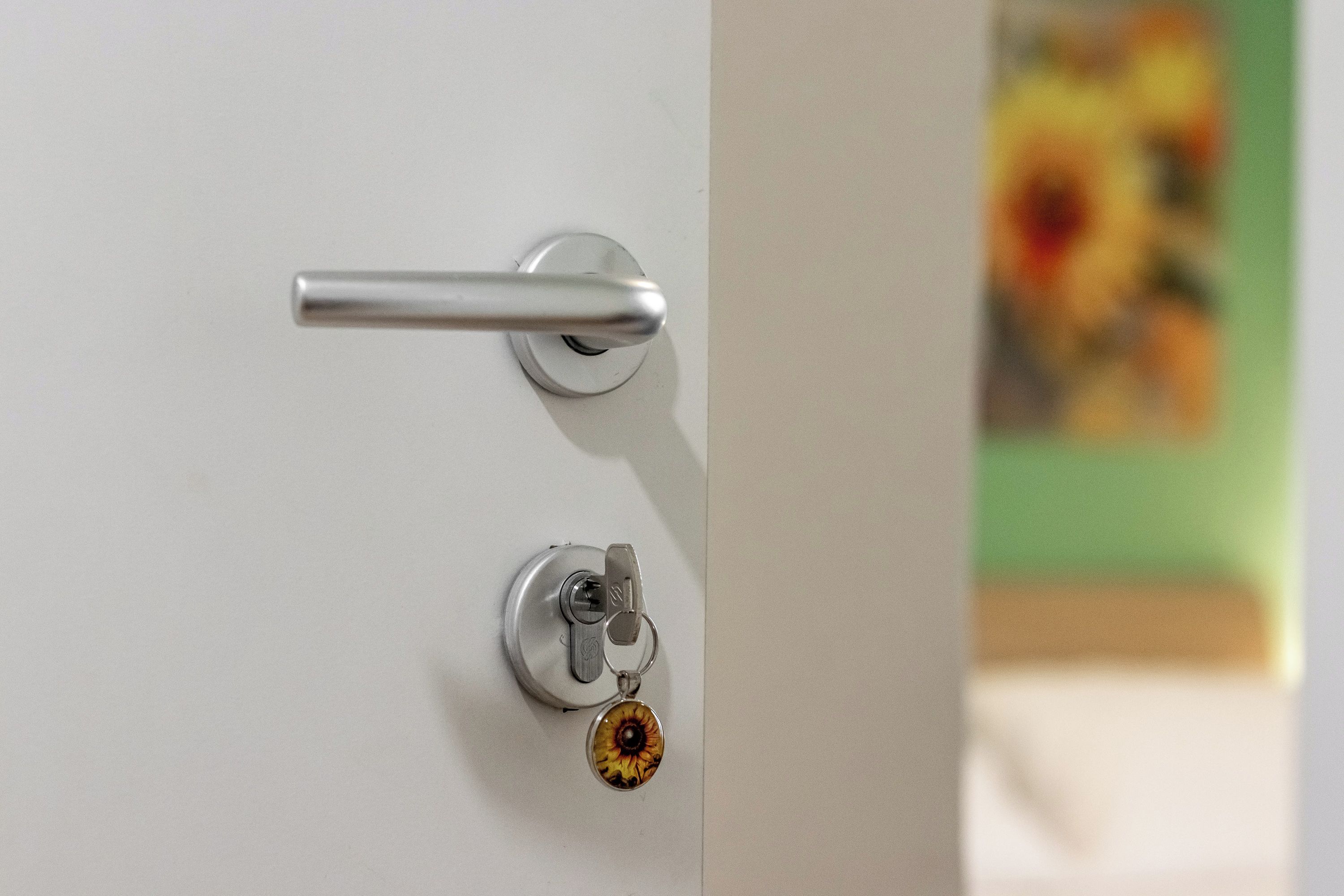 Una puerta con un picaporte metálico y una cerradura con un llavero.