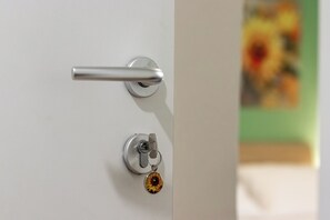 A door with a metallic handle and a keyhole with a keyring. - Cinqueterre in Fiore (La Spezia)