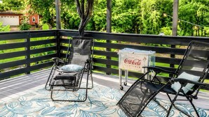A deck with two reclining chairs and a Coca-Cola cooler. - Tucked away in Tucker (Tucker)