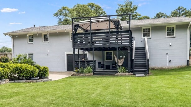 A two-story house with a covered patio area, a staircase, and a hammock. - Tucked away in Tucker (Tucker)