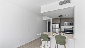 A modern kitchen with a central island, stainless steel appliances, and a bar stool seating arrangement. - 2-bedroom condo in marvelous Miami Views in the perfect spot! (Miami)