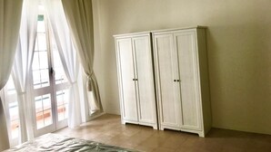 A room with a bed, a wardrobe, and a window with curtains. - Essenza Maison***** Spacious apartment in the ❤️ of Pescara, just a few meters from the sea. (Pescara)