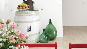 A dining area with a table set for a meal, a vase of flowers, and a white cabinet with a glass top. - Essenza Maison***** Spacious apartment in the ❤️ of Pescara, just a few meters from the sea. (Pescara)