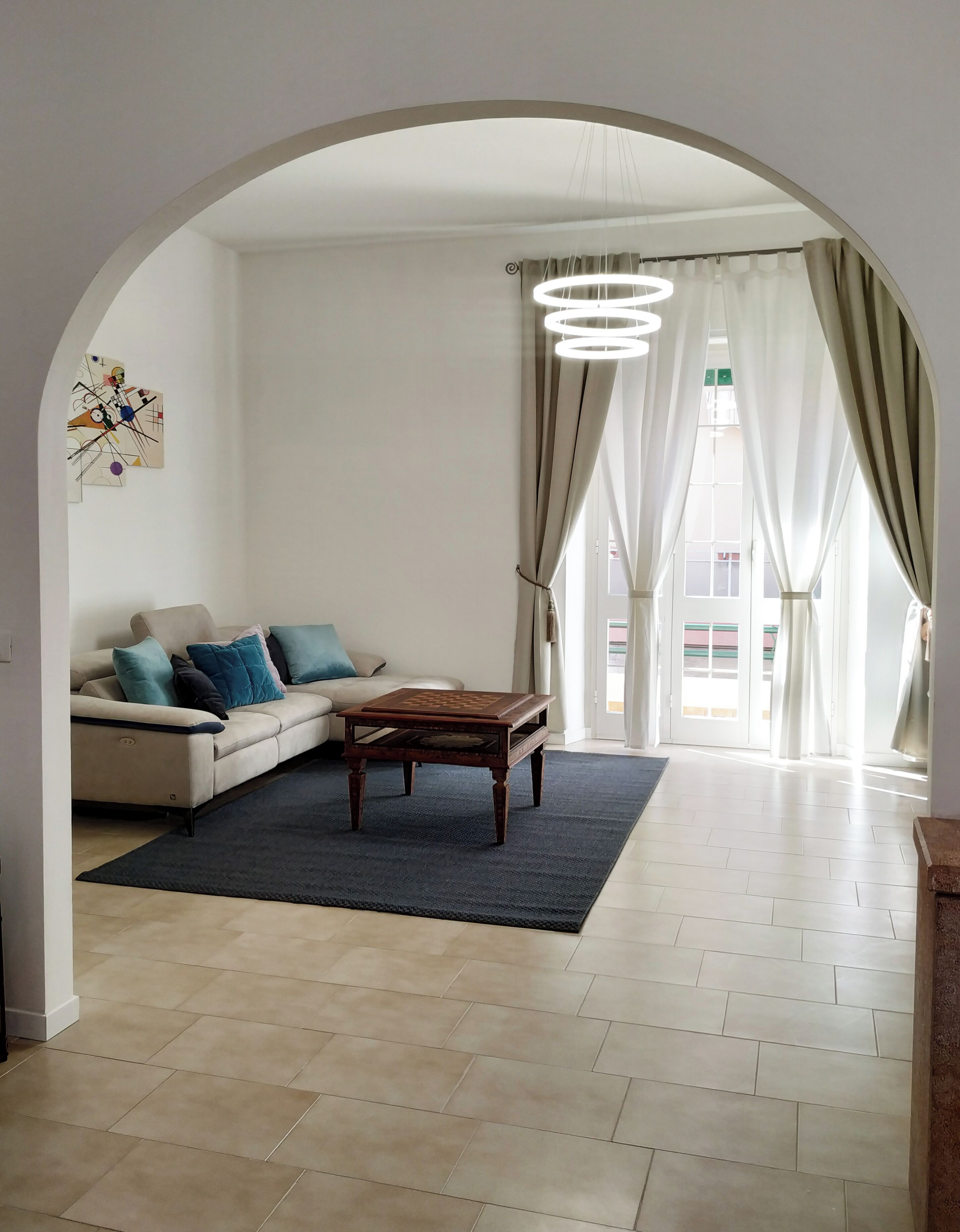 Un salon comprenant un canapé, une table basse, un tapis et un lustre.