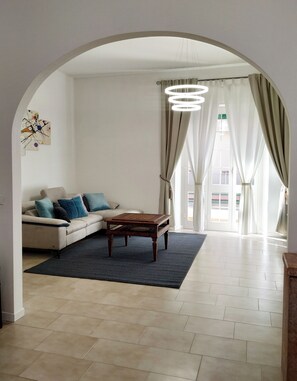Ein Wohnzimmer mit einer Couch, einem Couchtisch, einem Teppich und einer Chandelier.