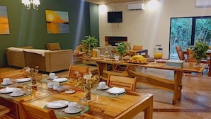 Comedor con mesas de madera dispuestas para una comida, rodeado de sillas.