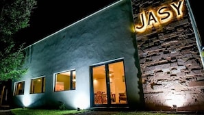 Un edificio con fachada moderna y pared de piedra con señalización iluminada.