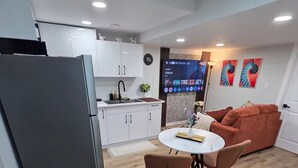 Un espace de vie compact comprenant une cuisine, un coin repas et un coin salon.
