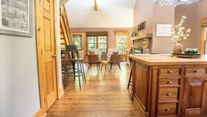 A kitchen with wooden cabinets, a bar area, and a dining space with chairs. - *NEW!* Cozy Watts Bar Getaway for Families & Friends (Rhea County)