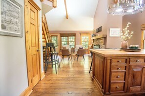 A kitchen with wooden cabinets, a bar area, and a dining space with chairs.