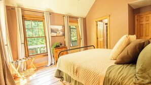 A bedroom with a large bed, wooden flooring, and a view of a dock through the windows. - *NEW!* Cozy Watts Bar Getaway for Families & Friends (Rhea County)