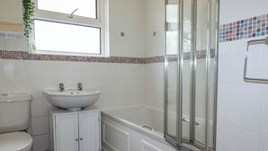 A bathroom with a toilet, sink, and shower. - Cloudbreak (Wadebridge)
