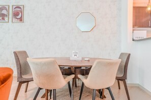 A dining area with a round table, four chairs, a wall-mounted mirror, and a sign indicating a room for orders. - HAVN - 2 Bed in Dubai Marina, 5 mins to Tram (Dubai)