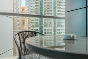 A balcony with a round table and a wicker chair, overlooking high-rise buildings. - HAVN - 2 Bed in Dubai Marina, 5 mins to Tram (Dubai)