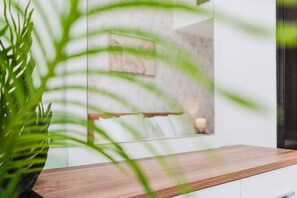 A modern interior with a wooden countertop and a potted plant. - HAVN - 2 Bed in Dubai Marina, 5 mins to Tram (Dubai)