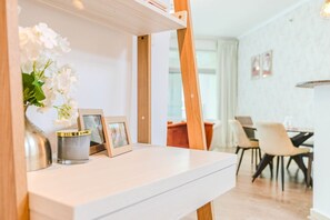 A white-framed mirror with a wooden frame, a vase with white flowers, and two picture frames on a white surface. - HAVN - 2 Bed in Dubai Marina, 5 mins to Tram (Dubai)