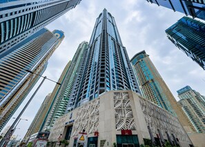 A high-rise building with a distinctive facade featuring geometric patterns and a prominent entrance. - HAVN - 2 Bed in Dubai Marina, 5 mins to Tram (Dubai)