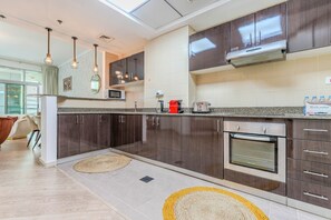 Eine moderne Küche mit dunklen Holzschränken, Edelstahlgeräten und einer Arbeitsplatte aus Granit.