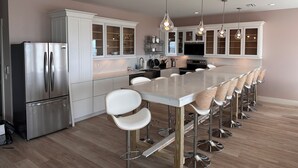 A modern kitchen with a central island, stainless steel appliances, and bar stools.