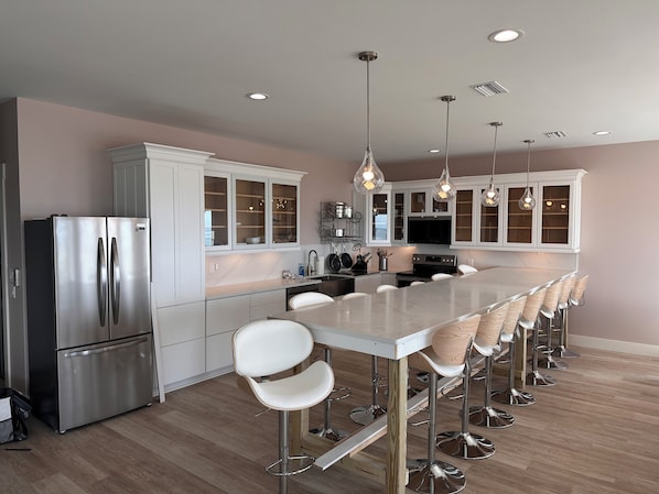 A modern kitchen with a central island, stainless steel appliances, and bar stools.