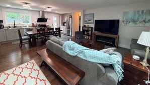 A modern living room with a sofa, TV, and fireplace. - Beach Wolf: ALL NEW, impeccable house in Southern Shores, 5 minute walk to beach (Kitty Hawk)