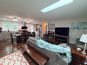 Ein modernes Wohnzimmer mit Sofa, Fernseher und Kamin.