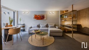 A modern living room with a sofa, coffee table, and bookshelf. - NOK Spacious 3BR Apartment Near Zona T, Bogota (Bogotá)