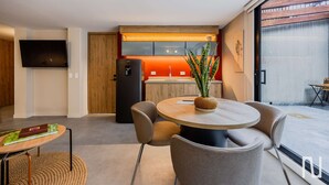 A modern kitchen with a built-in oven, a dining area with a round table and chairs, and a large window providing a view of the outdoors. - NOK Spacious 3BR Apartment Near Zona T, Bogota (Bogotá)