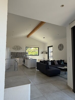 A spacious living area with a modern kitchen, a dining area, and a large window providing natural light. - Vacation Home for Rent (Belgodère)