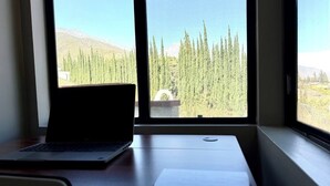 A laptop on a desk with a view of a mountainous landscape through a window. - Peaceful Foothill Getaway Tennis & 40+ Fruit Trees (Upland)