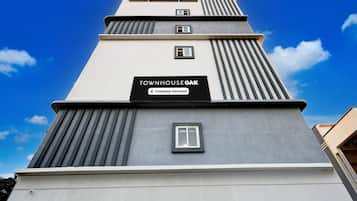 Um edifício de vários andares com uma placa indicando 'TOWNHOUSE OAK Company-Serviced'.