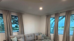 A modern living room with a sectional sofa, ottomans, and a patterned rug.