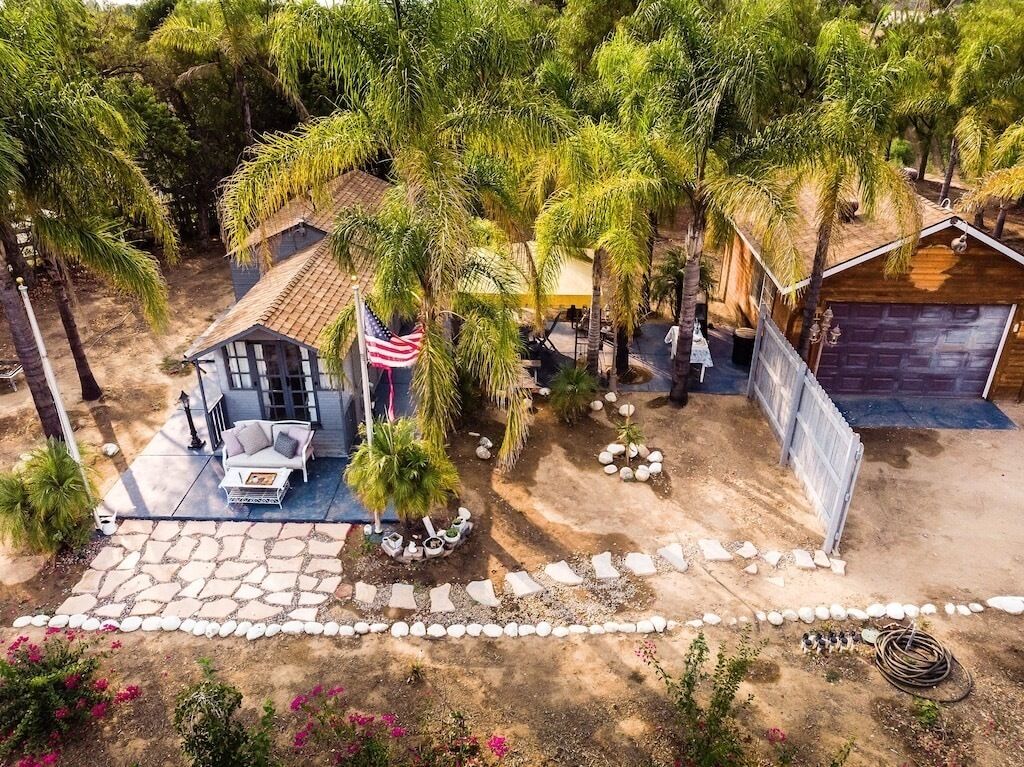 A residential property with a patio, outdoor seating, and a garage.